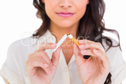 Pretty brunette breaking a cigarette