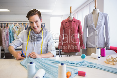 Student cutting fabric with pair of scissors