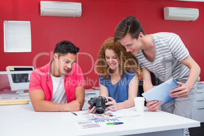 Smiling students working with camera and tablet