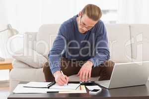Concentrated man using calculator counting his bills