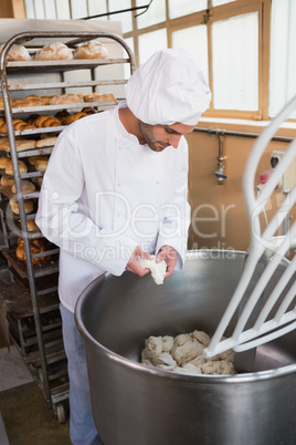Baker preparing dough in industrial mixer