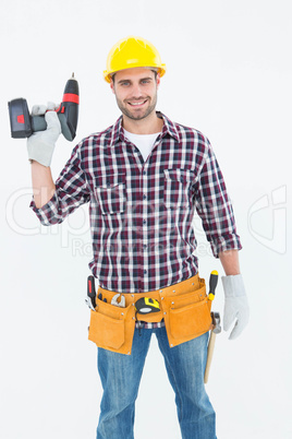 Confident male repairman holding drill machine
