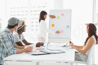 Businesswoman presenting and serious colleagues listening