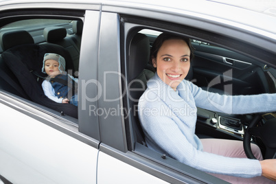 Mother driving with her baby in the car seat