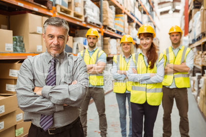 Smiling warehouse team with arms crossed