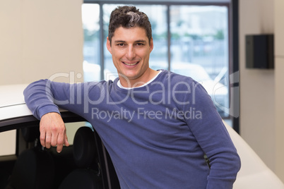 Smiling customer leaning on car