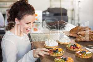 Pretty brunette picking a tart