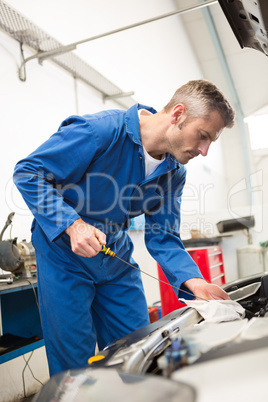 Mechanic checking the oil of car
