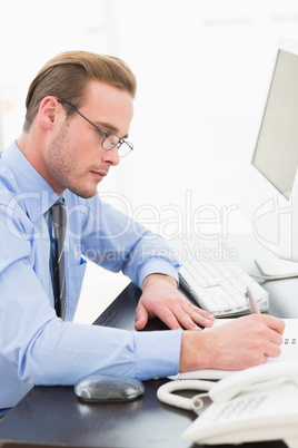 Businessman with glasses taking notes