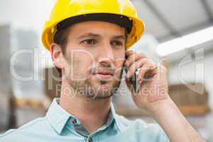 Worker using mobile phone in warehouse