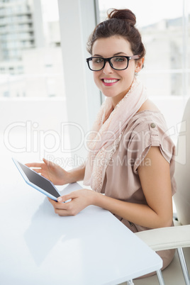 Smiling causal businesswoman using tablet