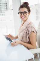 Smiling causal businesswoman using tablet