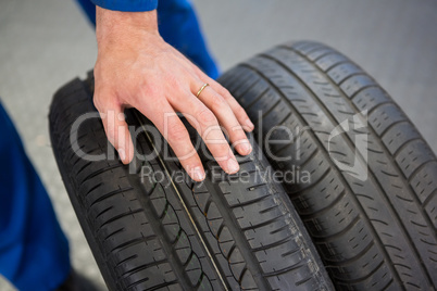 Mechanic rolling a tire wheel