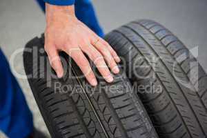 Mechanic rolling a tire wheel