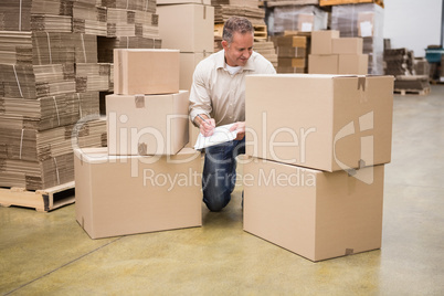 Warehouse worker checking his list on clipboard