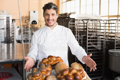 Smiling baker showing board of breads