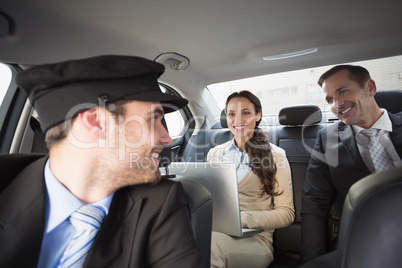 Handsome chauffeur smiling at clients