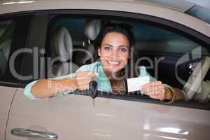 Smiling woman holding car key and business card