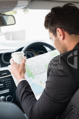 Young businessman reading a map