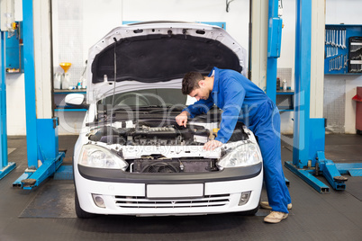 Mechanic examining under hood of car