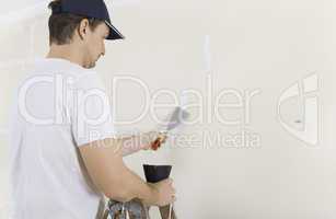 Mann spachtelt Risse an Wand