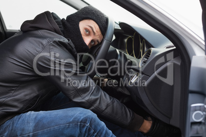 Thief breaking into a car