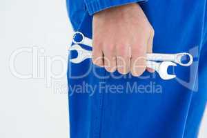 Male mechanic holding spanners