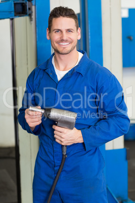 Smiling mechanic holding power drill