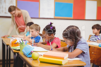 Cute pupils drawing at their desks