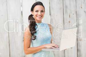 Stylish brunette using a laptop