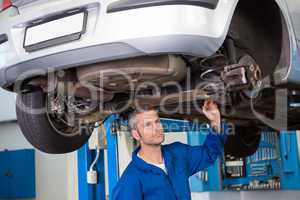 Mechanic examining under the car