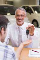 Smiling salesman giving a customer car keys