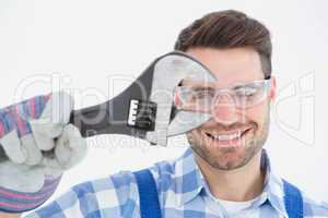 Confident repairman wearing protective glasses while holding wre