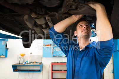 Mechanic examining under the car