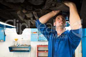 Mechanic examining under the car