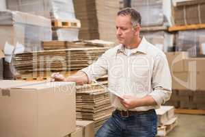 Warehouse worker checking his list on clipboard