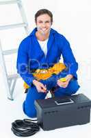 Happy electrician holding multimeter