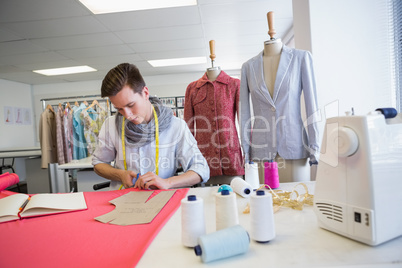 Student cutting fabric with pair of scissors