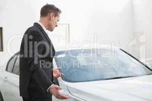 Businessman looking his car engine after breaking down