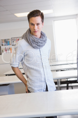 Smiling student standing and posing in classroom