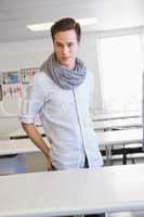 Smiling student standing and posing in classroom