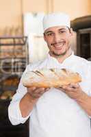 Baker holding freshly baked loaf