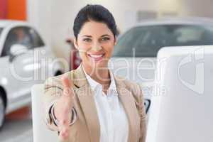 Smiling businesswoman reaching for handshake