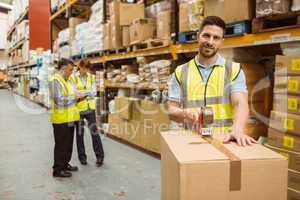 Smiling warehouse workers preparing a shipment