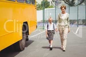 Mother walking her daughter to school bus