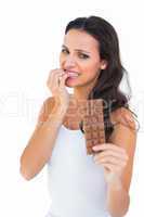 Pretty brunette fearfully looking at chocolate