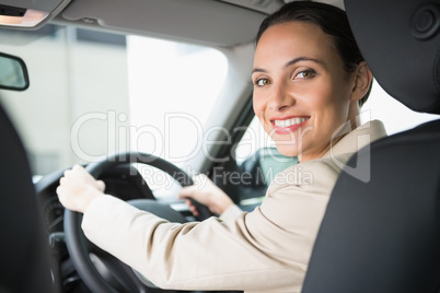 Pretty businesswoman smiling and driving