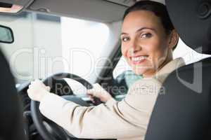 Pretty businesswoman smiling and driving