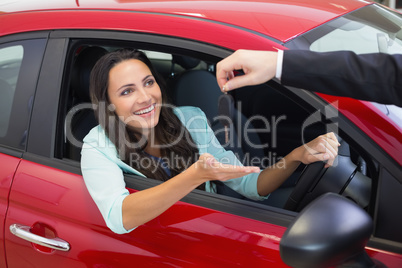 Businessman holding car keys by his fingertips