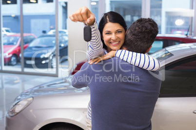 Smiling couple hugging and holding their new key